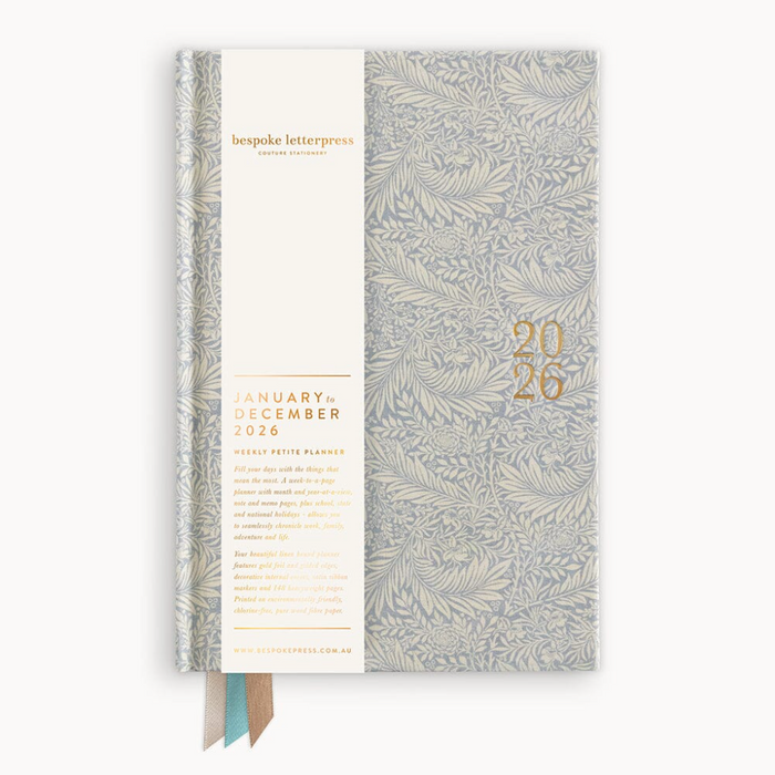 Light blue-grey embossed planner with gold text on a white background